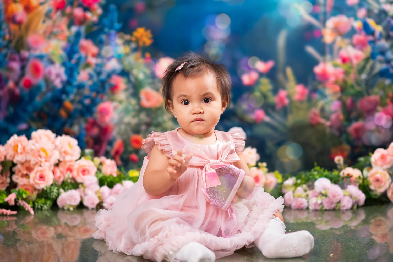 Julia sitting in her pink dress among flowers